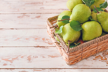 Basket with fresh ripe pears on table