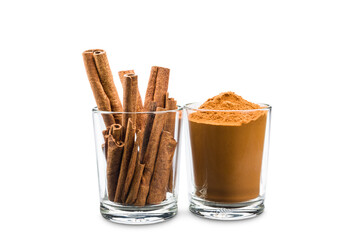 glass jars with ground cinnamon and sticks on white background