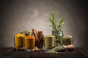 glass jars with various spices on wooden table
