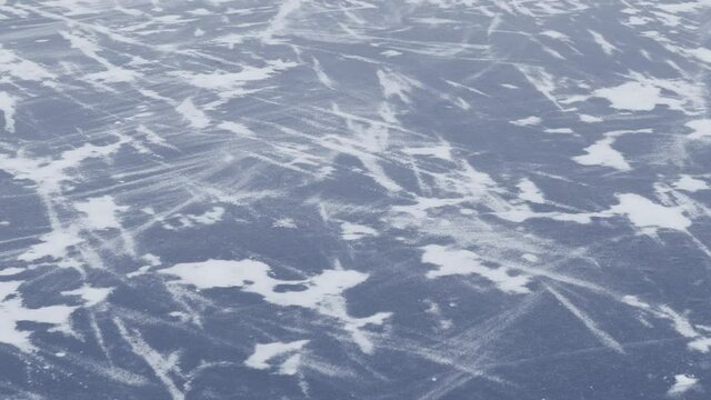 Ice surface on frozen winter river and fresh white snow blowing by wind. Abstract natural 4k video background.