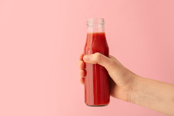 Hand with bottle of vegetable juice on color background