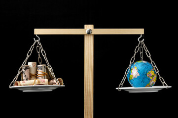 Earth and Money on a Two Pan Balance