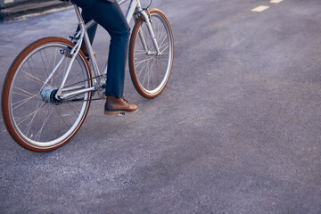 Fototapeta na wymiar Faceless man riding bicycle on asphalt road