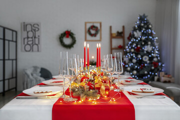 Beautiful table setting with Christmas decorations at home in evening