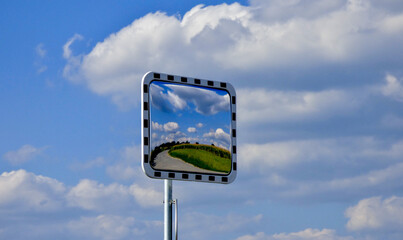 mais field in a traffic mirror, blue sky, white clouds