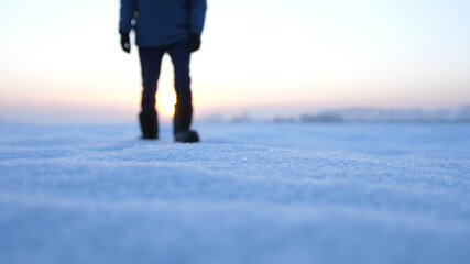 Male feet walking in deep snow. foot steps of hiker. recreational winter activity