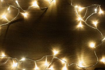 Garland of lamps christmas lights on light wood background with copy space