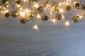 New year christmas composition from golden shiny and matte balls on light oak wood background with copy space