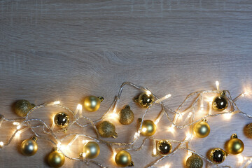 New year christmas composition from golden shiny and matte balls on light oak wood background with copy space