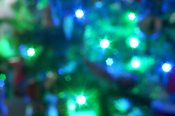 Green blue christmas lights bokeh in the form of six-pointed stars background