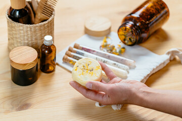 Eco friendly bath zero waste reusable set: salt, wooden comb, solid shampoo, soap, herbs in glass jar. Wooden background