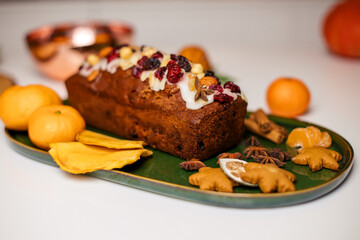 Christmas poppy seed cake covered with icing and decorated with raisins and walnuts on the holiday table.