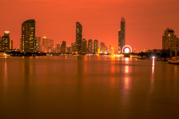 Obraz premium Blurred abstract background of high-rise buildings built by the river, lit at night, the distribution of residences of today's capital so