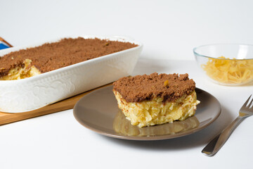 step-by-step recipe for the holiday of Hanukkah, a traditional sweet Kugel pie with noodles and custard, shortbread cocoa crumbs on top. on a light background in a baking dish