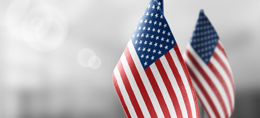 Small national flags of the United States on a light blurry background