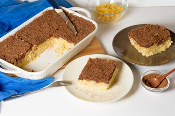 Hanukkah holiday, traditional sweet Kugel pie with noodles and custard, shortbread cocoa crumbs on top. on a light background in a baking dish. pie slices on a plate