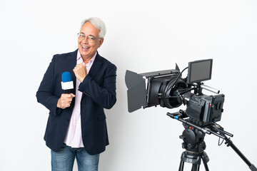 Reporter Middle age Brazilian man holding a microphone and reporting news isolated on white background celebrating a victory