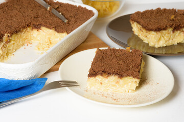 Hanukkah holiday, traditional sweet Kugel pie with noodles and custard, shortbread cocoa crumbs on top. on a light background in a baking dish. pie slices on a plate