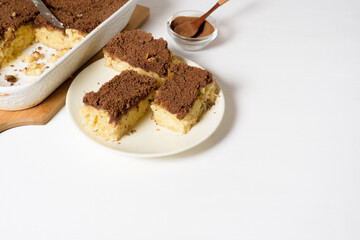 Hanukkah holiday, traditional sweet Kugel pie with noodles and custard, shortbread cocoa crumbs on top. on a light background in a baking dish. pie slices on a plate