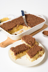 Hanukkah holiday, traditional sweet Kugel pie with noodles and custard, shortbread cocoa crumbs on top. on a light background in a baking dish. pie slices on a plate