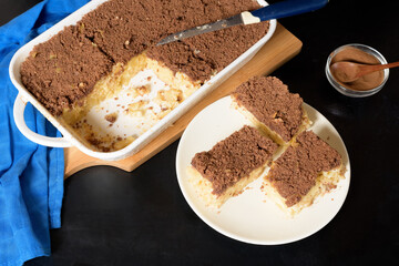 Hanukkah holiday, traditional sweet Kugel pie with noodles and custard, shortbread cocoa crumbs on top. on a light background in a baking dish. pie slices on a plate