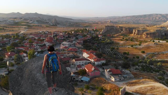 Aerial drone view of Cavusin village, Goreme, Cappadocia, Turkey. Tourist woman and tipical turkish village