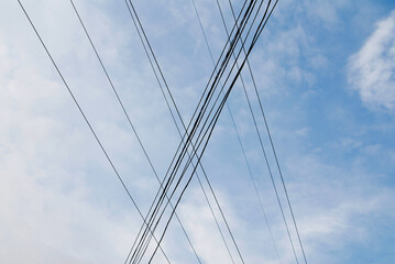 Electricity cables against the blue sky background.