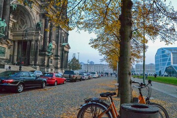 Fototapeta premium 05.11.2011. Berlin. Germany. In front of the Berliner Dom with cars, bicycle and yellow dried leaves on the cobblestone street.