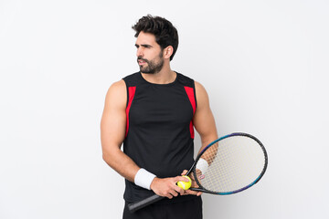 Young handsome man with beard over isolated white background playing tennis