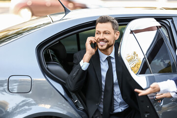 Businessman getting out of luxury car - Powered by Adobe