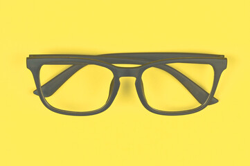 Glasses with transparent lenses with diopters on a yellow background. stylish accessory. Concept of...
