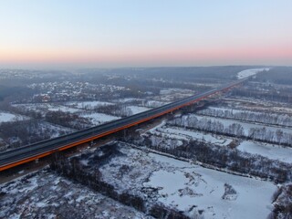 Aerial view of the Central Ring Road (CKAD) at sunrise. Beautiful panoramic landscape of a straight road overlooking the horizon. Travel by car in winter