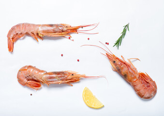 Large red shrimp and lemon with rosemary on a white background. Top view. Flat lay.