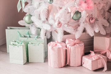 Gift boxes and pastel Christmas tree, wrapped presents and decor in modern style as holiday home decorations