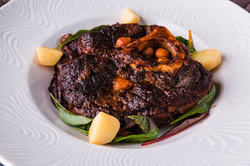 Osso Buko - stewed beef shank with root vegetables, herbs and wine with boiled mini potatoes