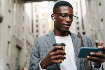 Attractive young african businessman in wireless earphones