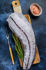 Fototapeta na wymiar Fresh Raw grenadier macrurus white fish on a wooden cutting board. Blue background. Top view