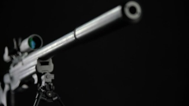 focus and pan from the top of the silencer to the butt of Sniper rifle Sako TRG 41 on black background