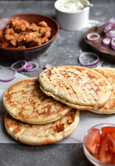 Ingredients for making pita with chicken. Healthy fast food. Dark background. Tomatoes, red onion, chicken nuggets.