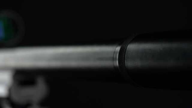 focus and movement from the butt of the silencer to the top of Sniper rifle Sako TRG 41 on black background