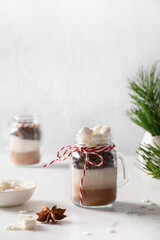 Obraz na płótnie Canvas Christmas edible gift in glass jar for making chocolate drink on white background. Vertical.