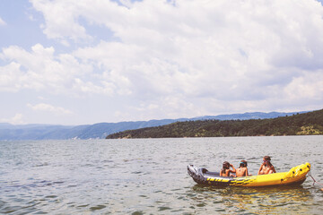 Naklejka na ściany i meble Happy children have summer fun on water, kayaking, beautiful nature landscape
