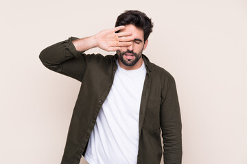 Young handsome man with beard over isolated background with tired and sick expression