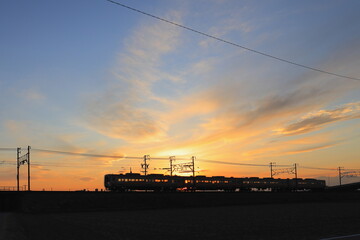 夕焼けを背に走る電車