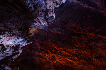 Stalagmites lit by colored lights, cave, Lozère, Occitanie, France