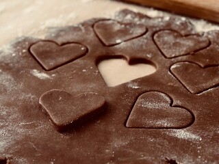 Valentine's day. Cutting out hearts from rolled dough for making Christmas cookies.