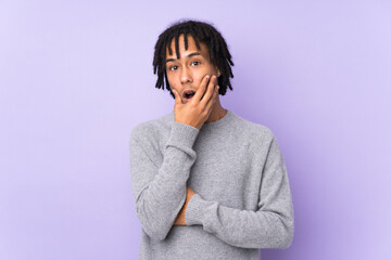 Young african american man isolated on purple background surprised and shocked while looking right