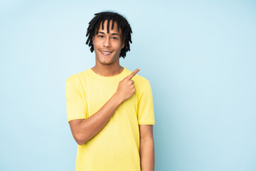 Young african american man isolated on blue background pointing to the side to present a product