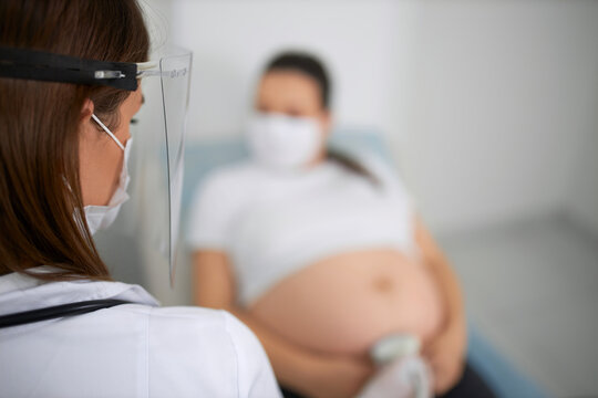 Doctor In Mask Doing Ultrasound Checkup For Pregnant Woman