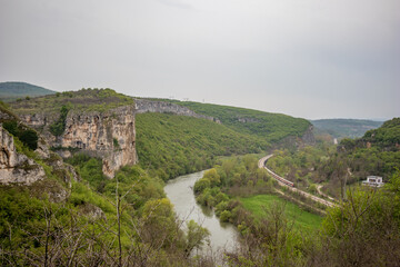 Fototapeta na wymiar Iskar river gorge moody day landscape view from above near main entrance of Prohodna cave, Northwestern Bulgaria